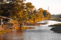 A traditional wooden t fishing trap with a golden orange beautiful forest along river in Thailand background Royalty Free Stock Photo