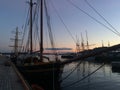 A traditional wooden viking long tied up and docked in Oslo fjord Harbour with a colorful sunset in the background