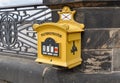 Traditional yellow postbox attached to decorative sandstone balustrade in historic Dresden