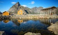 Traditional yellow rorbu house in drying flakes for stockfish cod fish in norwegian fjord in summer. Sakrisoy fishing village, Royalty Free Stock Photo
