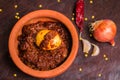 Traditionally cooked meat food item in pot vessel with ingredients .