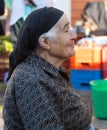 Traditionally dressed old woman farmer selling her produce at th