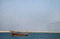 A traditional fishing boat in Bahrain seen through fishing net Royalty Free Stock Photo