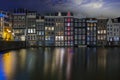 Traditonal houses at the Damrak in Amsterdam in the Netherlands by night