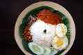 Traditonal Malaysia Asian food Nasi Lemak on a banana leaf in a wooden bamboo plate Royalty Free Stock Photo