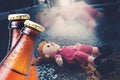 Traffic accident. Close-up of two bottles of beer against the background of a sad doll lying on the road. The concept of Royalty Free Stock Photo