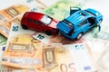 traffic accident of two toy cars and a police car helping in a european banknote background Royalty Free Stock Photo