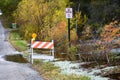 Traffic barricade with solar lamp and No Parking Any Time sign along a flooding lake during autumn Royalty Free Stock Photo