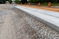 Traffic barricades alongside a new street under construction, gravel road bed with extruded concrete curb