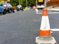 Traffic cone on focus, workers painting the fresh asphalt