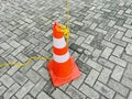 Traffic cone on a paved street with interlocking gray bricks Royalty Free Stock Photo