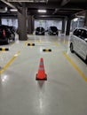 A traffic cone is placed in one of the empty parking spaces, designated for a specific vehicle. Royalty Free Stock Photo