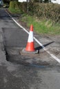 Traffic cone and road subsidence around manhole Royalty Free Stock Photo