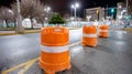 Traffic cones on an empty city street at night with bright lights. Royalty Free Stock Photo