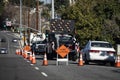 Traffic cones in a line with a a right lane closed sign and electronic traffic arrow