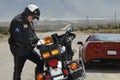 Traffic Cop Writing Against Motorcycle Royalty Free Stock Photo