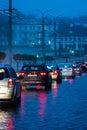 Traffic jam in the city at night during the rain. Rear view of cars standing on the road and red headlights. Reflection of red car Royalty Free Stock Photo