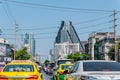 Traffic jam condition on the road with many congested electricity wire around and modern buildings as background in Bangkok;