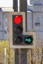 Traffic light with forbidding red signal and permissive green signal of right arrow section on city street in sunny day closeup