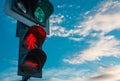 Traffic light with green light for cars and red light for people. Stoplight against blue sky with white clouds Royalty Free Stock Photo