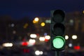 Traffic light green signal on the night on the back lights of cars.