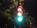 Traffic light at night-time showing red, yellow, and green Royalty Free Stock Photo