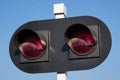 A traffic light for a railway crossing, two red lights against a blue sky. forbidding sign for leaving the tracks. traffic safety Royalty Free Stock Photo