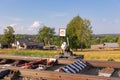 Traffic light on the railway in the village against the background of the forest and blue sky with white clouds on a bright sunny Royalty Free Stock Photo