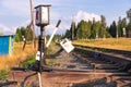 Traffic light on the railway in the village against the background of the forest and blue sky with white clouds on a bright sunny Royalty Free Stock Photo