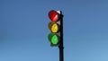 Traffic light with red, yellow and green colors on isolated on blue sky background Royalty Free Stock Photo