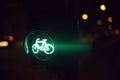 traffic light showing green bicycle symbol at night with colorful lights in blurred background Royalty Free Stock Photo