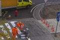 Traffic line painting. Workers are painting white street lines on pedestrian crossing. Road cones with orange and white Royalty Free Stock Photo