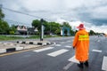 Traffic officer wearing orange raincost with control and directing traffic in countryside Royalty Free Stock Photo
