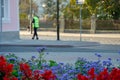 The traffic police inspector is doing his job. A man stands on a background of flower beds. Funny policeman loves flowers. Law