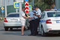 A traffic policeman talks to a man on the road or checks a document