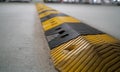 Traffic safety speed bump on an asphalt road in a parking area. Speed bumps or speed breakers are the common name for a family Royalty Free Stock Photo