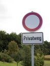 Traffic sign with German text `Privatweg` translates into `Private road` in English language