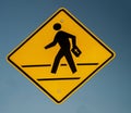 Traffic sign with graphic of a person crossing a street with a bible floating on a blue sky Royalty Free Stock Photo