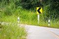 Traffic sign indicating a curve to the left and straight ahead a row rural forest grass.Out of focus on The main subject Royalty Free Stock Photo