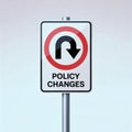 Traffic sign indicating a U-turn with the words \'Policy Changes\' against a neutral gradient background Royalty Free Stock Photo