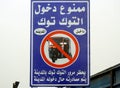 A traffic sign on the road, Translation of Arabic (No TukTuk Tok Tok allowed inside the city, auto rickshaw expropriation if Royalty Free Stock Photo