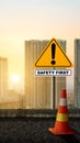 A traffic sign with \'safety first\' text and a traffic cone Royalty Free Stock Photo