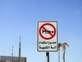 A traffic sign at the side of the road, Translation of the Arabic text (Car horn is not allowed), a forbidden zone area