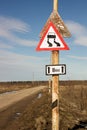 Traffic sign slippery road hung over another old sign Royalty Free Stock Photo