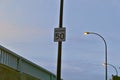 A traffic sign speed limit of 50 Km/hr in a sector over a bridge with a background of a cloudy blue sky and street light Royalty Free Stock Photo