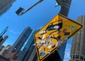 Traffic sign warning of curvy road ahead, covered with stickers and found on Wacker Dr with building architecture lining the