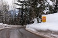 Red triangle road traffic warning sign - Other Danger. Crossroads with cross-country skis paths . Snow covered road, trees and mou