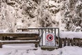 No entry, Power station - Warning sign hung on a metal gate. Snow-covered trees and a wooden fence around Royalty Free Stock Photo