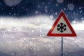 Traffic sign warns of snow and ice at road in winter Royalty Free Stock Photo