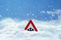 Traffic sign warns of snow and ice at road in winter Royalty Free Stock Photo